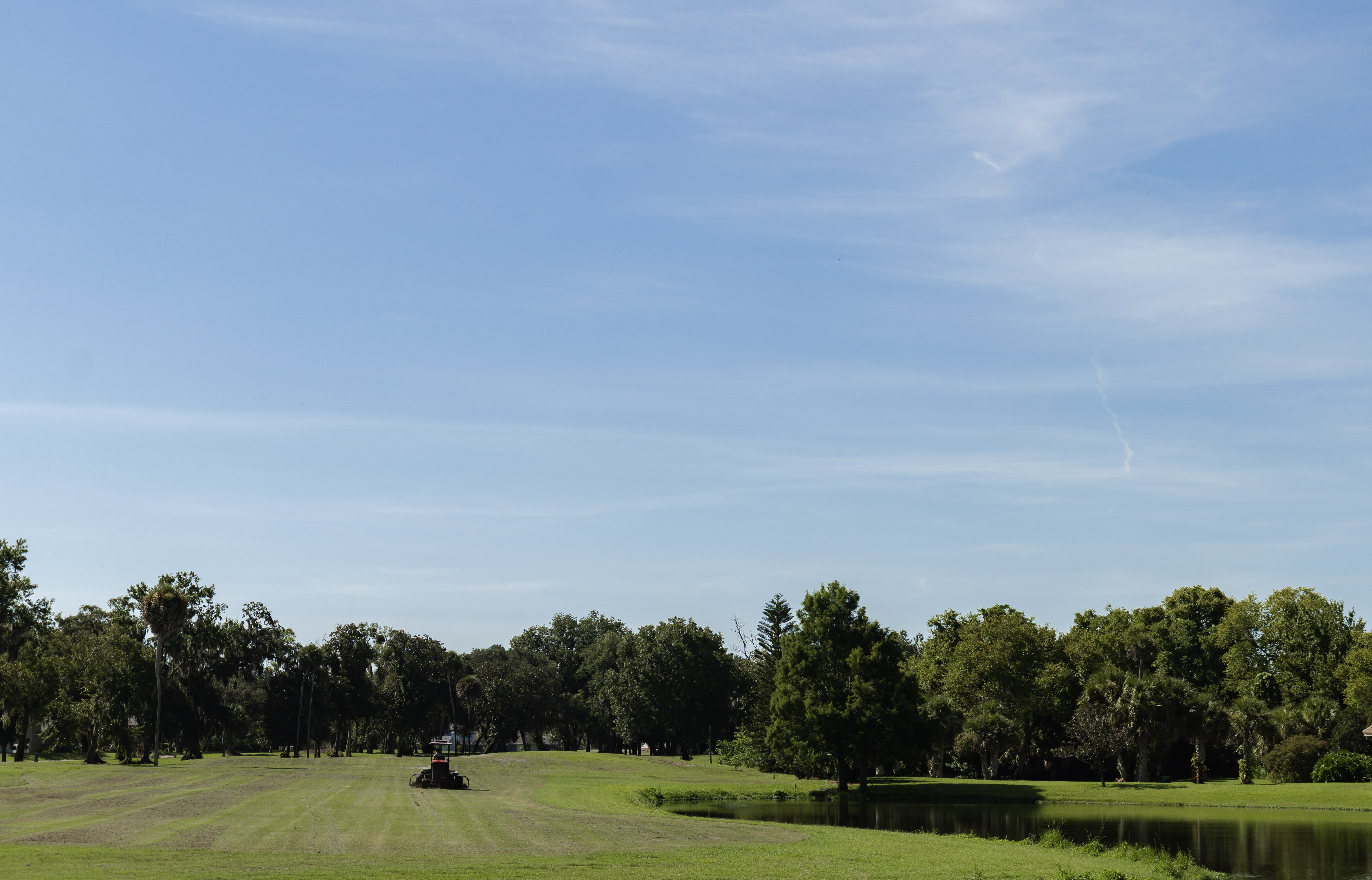 Lawn mower in front of the course lake